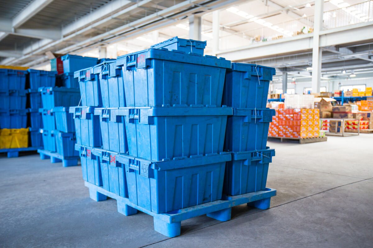 Rows of reusable moving totes stacked and ready for rental